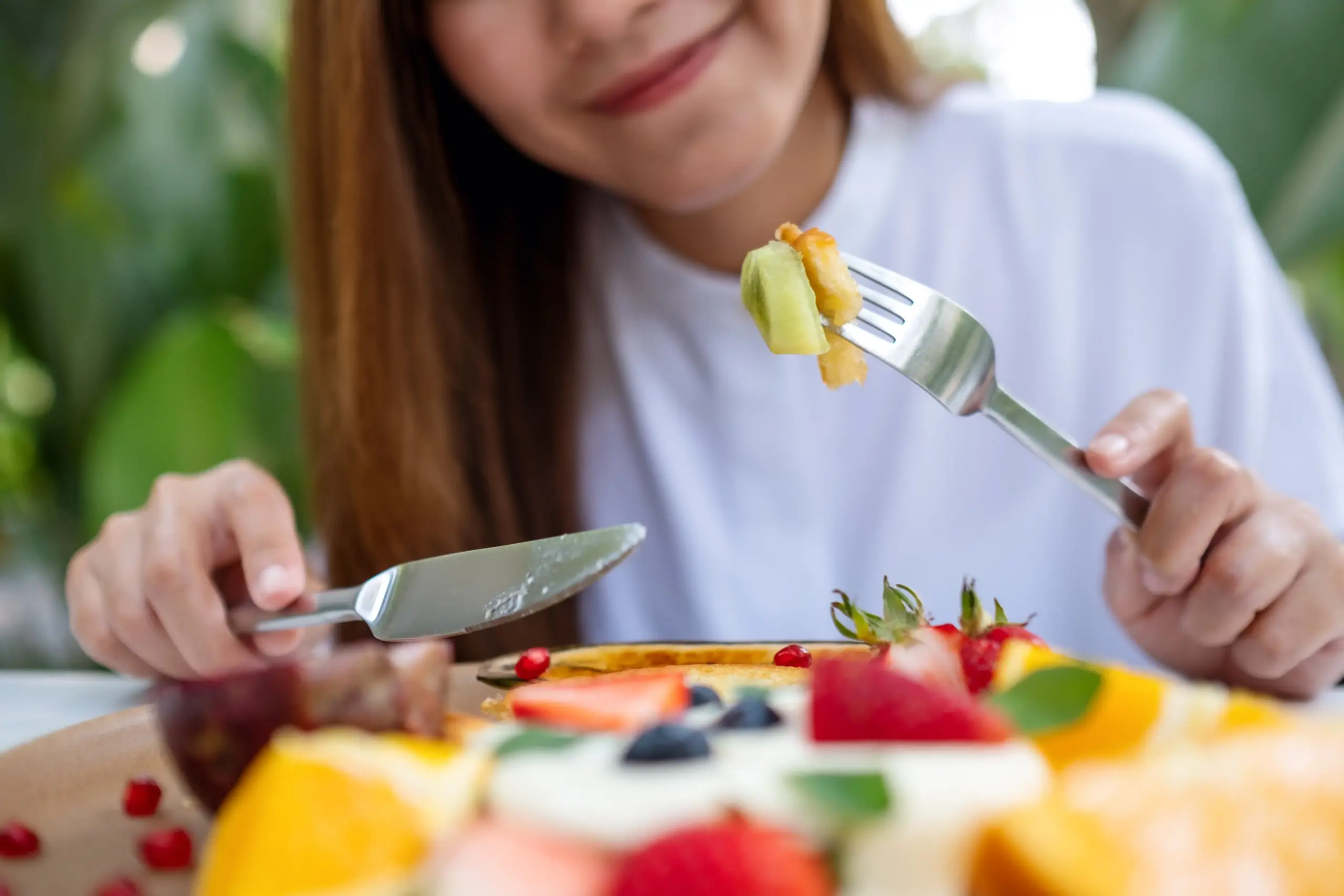 Ragazza che mangia frutta fresca percorso per migliorare le abitudini alimentari con la nutrizionista a Bassano del Grappa